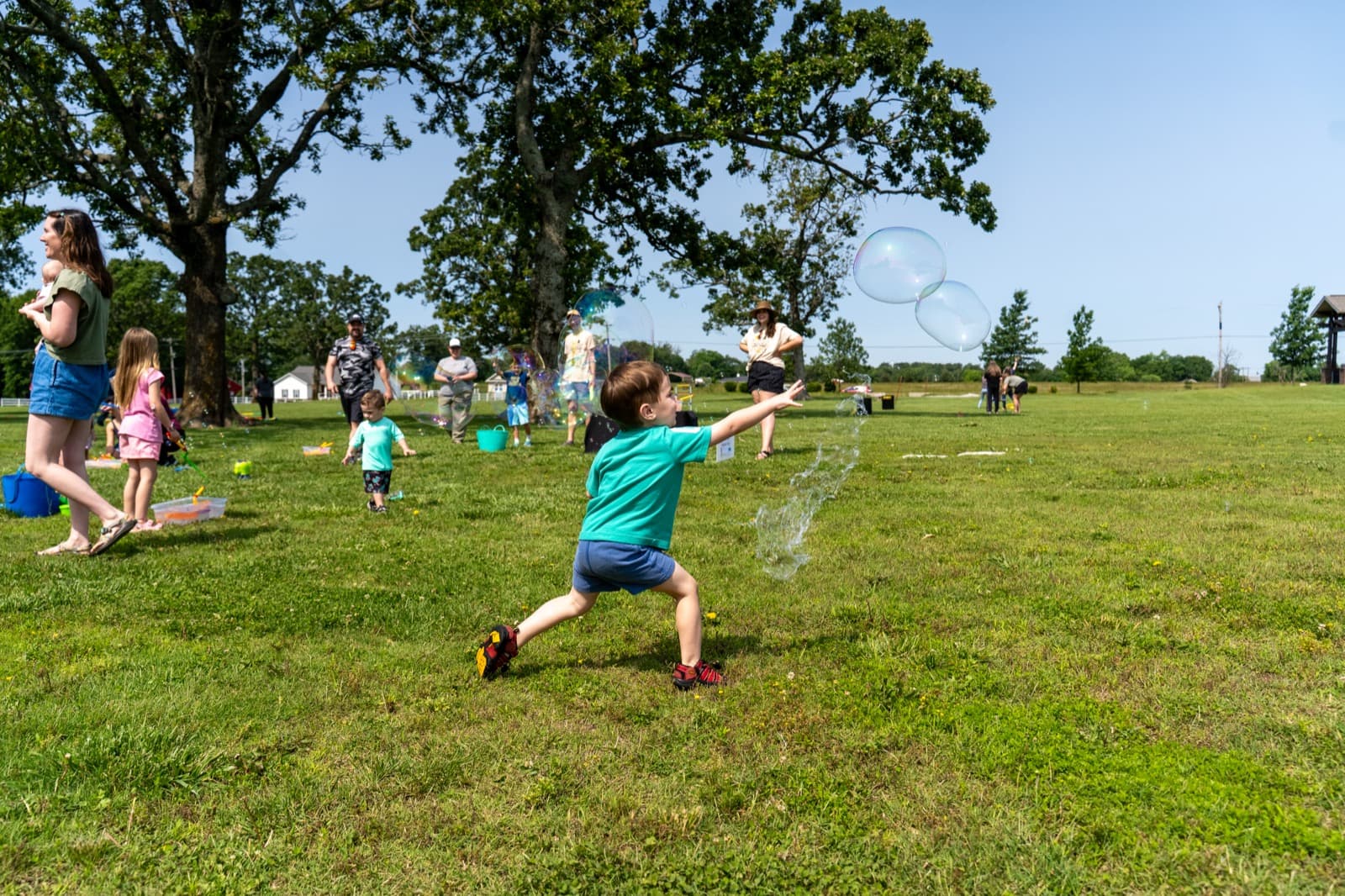 A child runs across the grass at an outdoor community event.