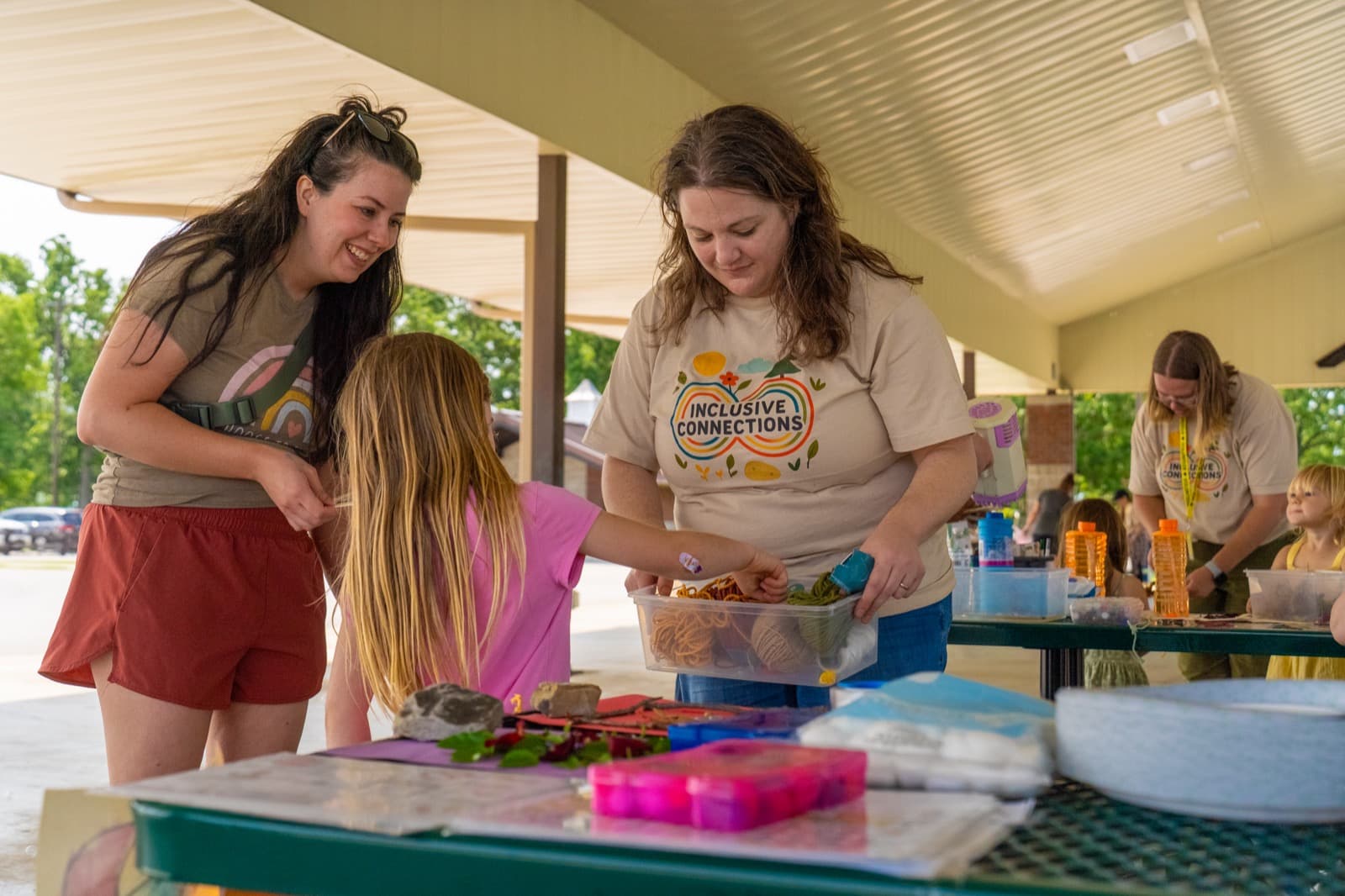 Volunteers preparing activity supplies on a table at a community event.